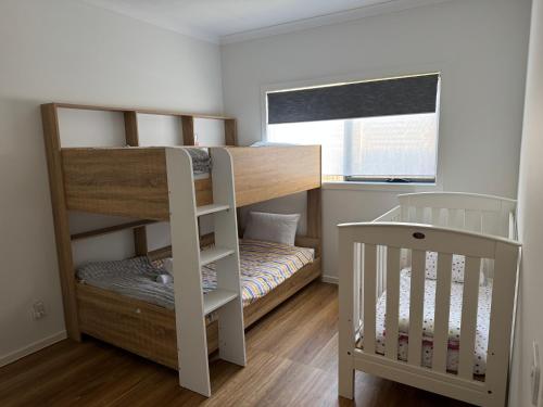 een kleine kamer met een stapelbed en een wieg bij Nine in Grovedale