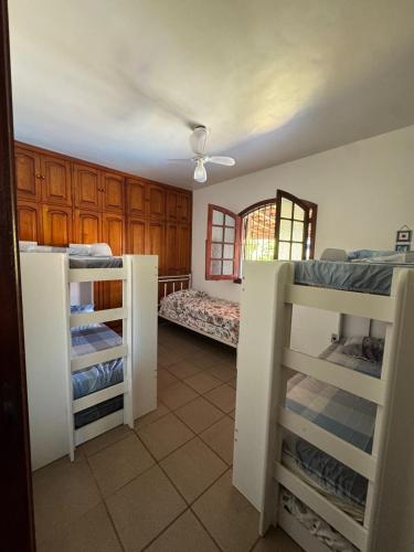 a room with two bunk beds and a bed at Casa com piscina Perto Da Praia Em FIGUEIRA in Arraial do Cabo