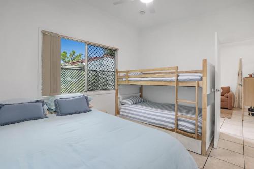 a bedroom with two bunk beds and a balcony at 1/24 Birch Street in Amity Point