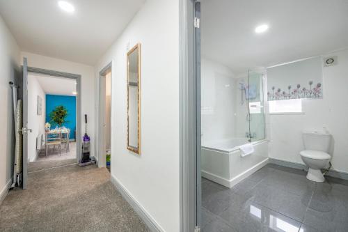 a white bathroom with a tub and a toilet at 2AA Spacious & Innovative Stay in Beeston