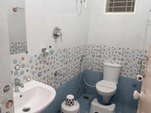 a bathroom with a toilet and a sink at Sai Inn Mysore in Mysore