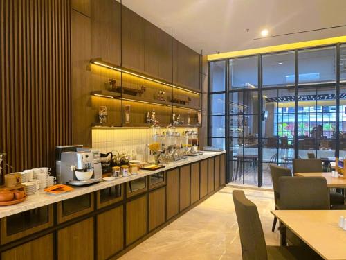 a restaurant with a bar with tables and chairs at Citadines Connect Airport Jakarta Hotel in Tangerang