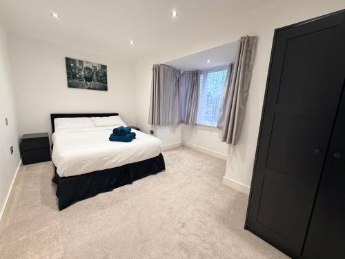 a bedroom with a bed with a teddy bear on it at Sleek Modern 2BDR Flat in Charming Pinner in Northwood