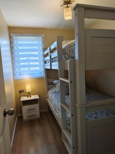 a bunk bed room with two bunk beds and a window at Cabañas Perlas del Sur in Valdivia