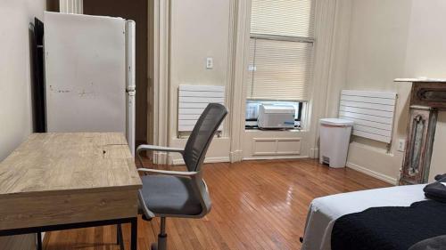 a bedroom with a desk and a chair and a refrigerator at New York City Guesthouse 3 in New York