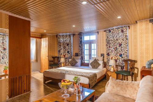 una camera da letto con un letto e un soggiorno di Heritage Bungaow a Srinagar