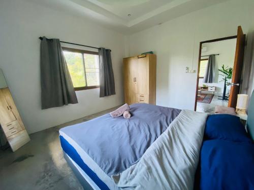 een slaapkamer met een bed met een roze knuffeldier erop bij Sabai Homes 3 in Mae Haad