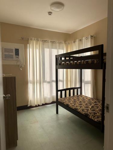 a bedroom with two bunk beds and a window at 2 Bedroom Condominium in Cagayan de Oro