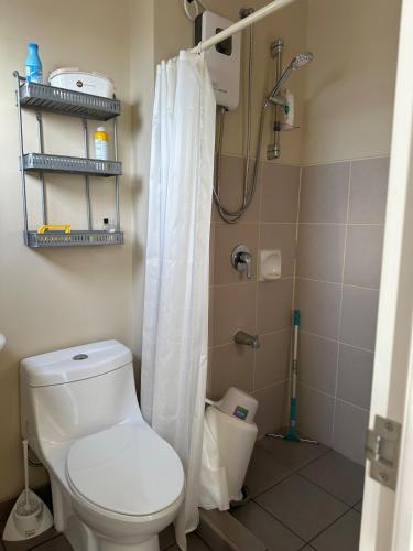 a bathroom with a toilet and a shower at 2 Bedroom Condominium in Cagayan de Oro
