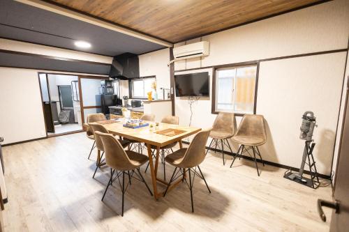 a dining room with a table and chairs at nestay villa osaka imazato in Osaka