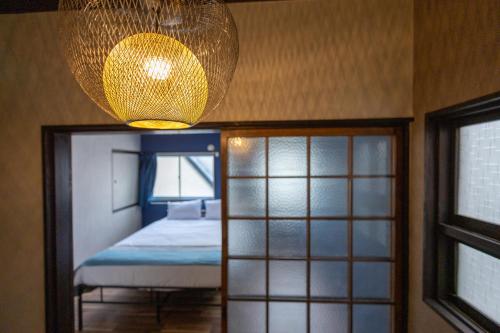 a bedroom with a bed and a chandelier at nestay villa osaka imazato in Osaka