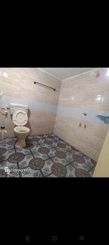 a bathroom with a toilet and a tile floor at M R ViLLA HAMPI magic rock villa in Hampi