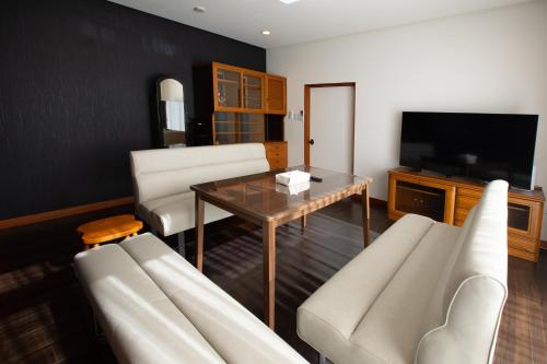 a living room with a couch and a table at 浜の宿後楽庵-閑静な住宅街に佇む日本庭園付きの落ち着いた宿-歩いて後楽園へ-駐車場無料 in Okayama
