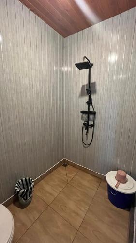a small bathroom with a shower and a toilet at Padangsari Cabin House in Diyeng