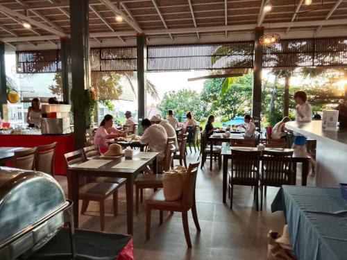 een groep mensen die aan tafels in een restaurant zitten bij Phi Phi Mountain Beach Resort SHA Certified in Phi Phi Don