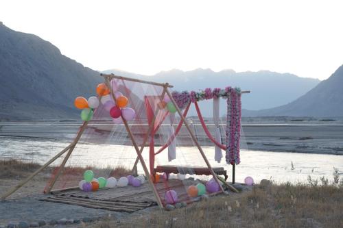een schommel met een bos ballonnen eraan bij Dera Lamsa Resort Shigar in Shigar
