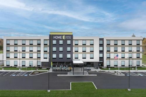 a large white building with a sign on it at Home2 Suites By Hilton Syracuse Liverpool Airport Area in Liverpool