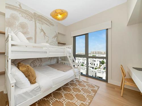 a white bunk bed in a room with a desk and a window at The Town Square Suite Luxury 2BR Near Qudra Lake in Dubai