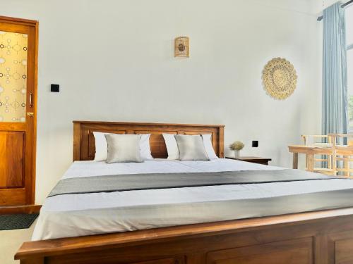 a bedroom with a large bed with a wooden headboard at Crystal Pearl Villa, Weligama - 3min to beach in Weligama