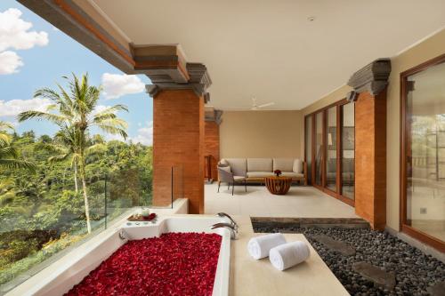 a bathroom with a bath tub filled with red flowers at Padma Resort Ubud in Payangan