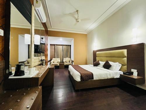 a hotel room with a bed and a bathroom at Hotel Asia Vaishnodevi Katra in Katra