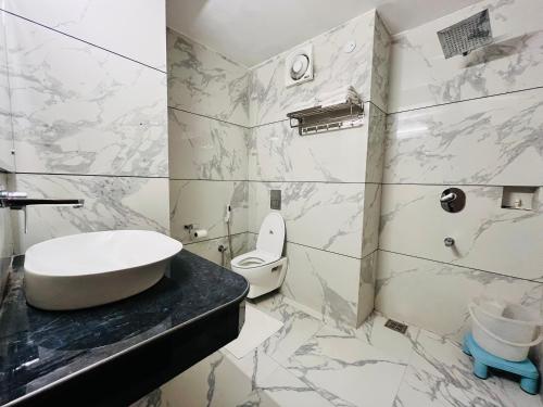 a bathroom with a sink and a toilet at Hotel Asia Vaishnodevi Katra in Katra