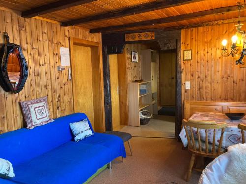 een woonkamer met een blauwe bank en een tafel bij Chalet Lueg uf Belalp in Rosswald