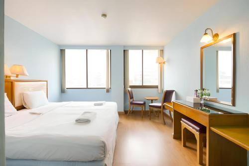 a hotel room with a bed and a desk and a mirror at Wish Inn Chidlom - Ratchadamri 2 in Pratunam