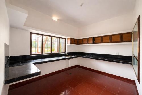 an empty kitchen with black and white walls and a window at Golden Breeze Bekal in Bedadka