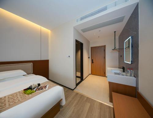 een hotelkamer met een bed en een wastafel bij Leaf Hotel in Yantaiqian