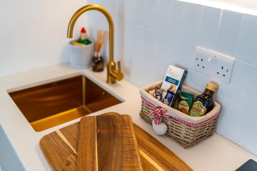 a kitchen counter with a sink and a basket of food at Charming coastal escape in Eastbourne