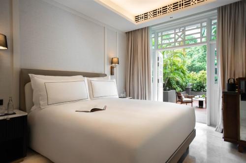 een slaapkamer met een groot wit bed en een groot raam bij METT Singapore in Singapore