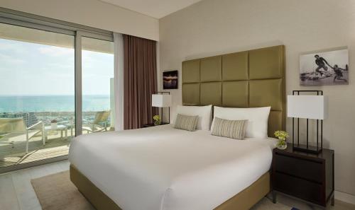 a bedroom with a large bed and a large window at The Ritz-Carlton, Herzliya in Herzliya