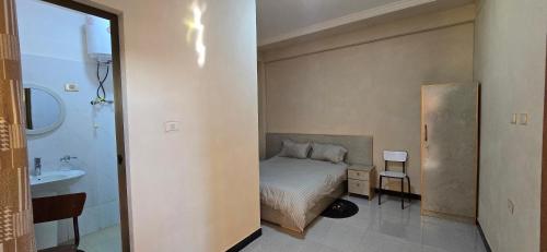 ein kleines Schlafzimmer mit Bett und Waschbecken in der Unterkunft Temesegen Hotel in Aksum