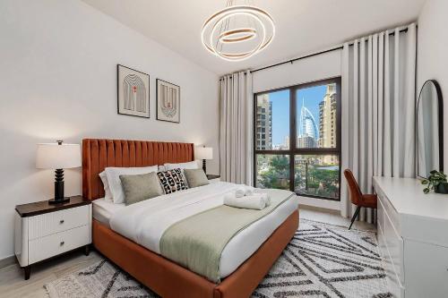 a bedroom with a bed and a large window at Asayel Apartments in Dubai
