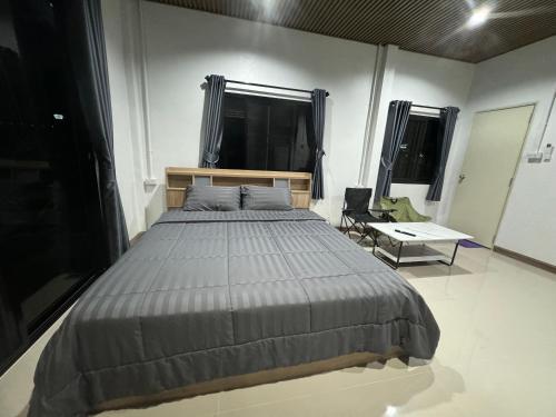 a bedroom with a large bed and a chair at บ้านไร่สกายดาวเขาใหญ่ in Ban Nong Khung