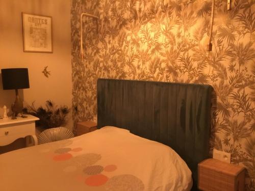 a bed with a black head board in a bedroom at Cosy corner in La Celle-sous-Gouzon