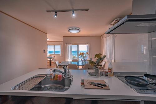 een keuken met een spoelbak en een aanrechtblad bij 波音ハウス in Yugawara