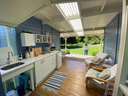 a kitchen with blue walls and a person walking outside at Okuti Country Cottage, a private and peaceful retreat in Little River