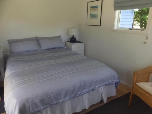 a bedroom with a bed and a window at Okuti Country Cottage, a private and peaceful retreat in Little River