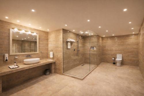 un bagno con lavandino e doccia in vetro di Hotel Cardinal Express Oxmo Near IGI Airport Delhi With Free Aiport Drop a Nuova Delhi