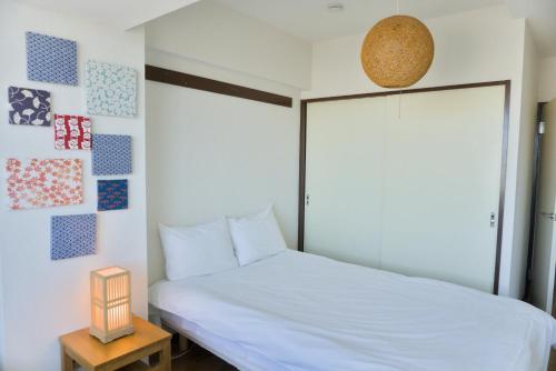 a bedroom with a white bed and a lamp at Nishibi in Tokyo