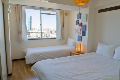 a hotel room with two beds and a window at Nishibi in Tokyo