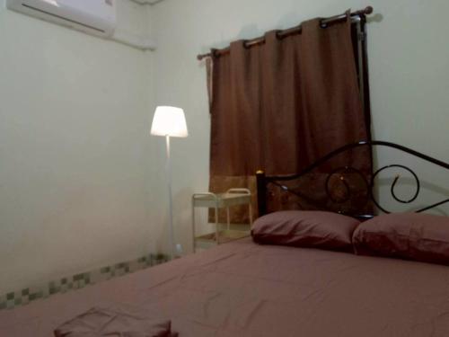 a bedroom with a bed and a lamp and a window at Future house in Ban Khi Lek Luang (1)