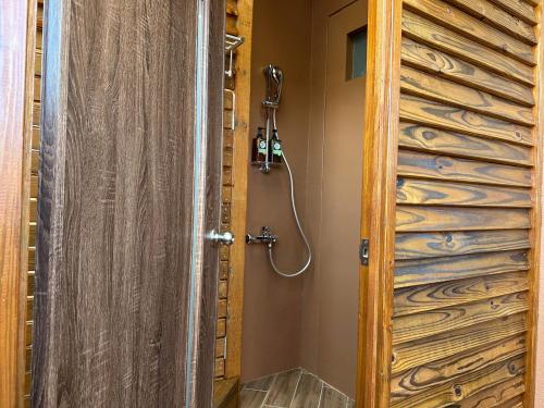 un bagno con doccia e porta in legno di 寄寓 Ji-Yu a Hsi-ti-tzu