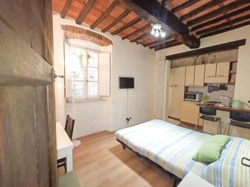 a small bedroom with a bed and a kitchen at Il giardino segreto in Lucca