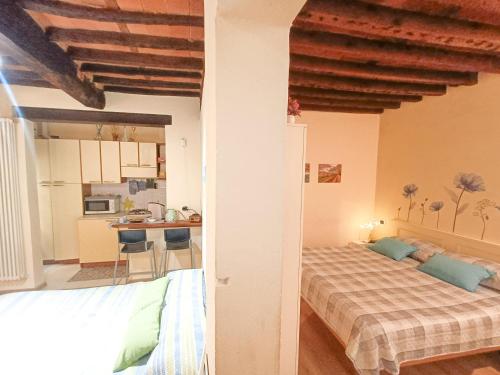 a bedroom with two beds and a kitchen in the background at Il giardino segreto in Lucca