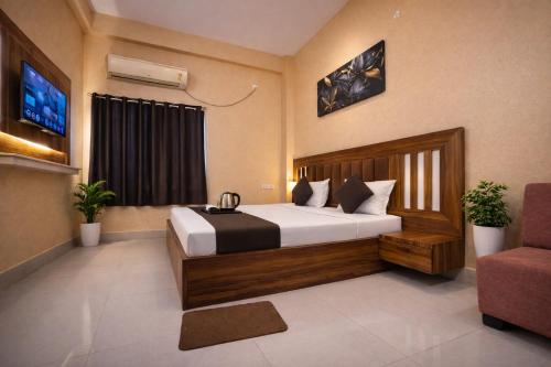 ein Hotelzimmer mit einem Bett und einem Stuhl in der Unterkunft Roomssolution ! Best Hotel In Patna in Gulzārbāgh