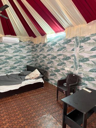 a room with a bed and a table in a tent at SS Aadhya Retreat in Payikāpuram