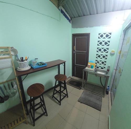 a kitchen with a table and stools in a room at 103 Lovely AC apartment with private kitchen in Bangkok